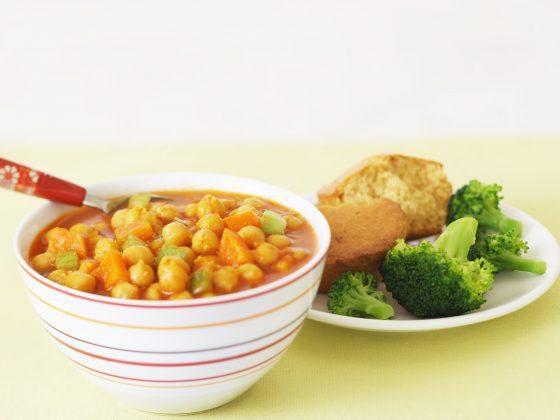 bowl of chickpea chowder with broccoli and cornbread on the side