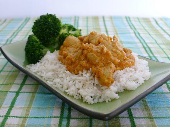 sri lankan chicken on top of white rice with broccoli
