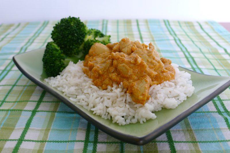 sri lankan chicken on top of white rice with broccoli