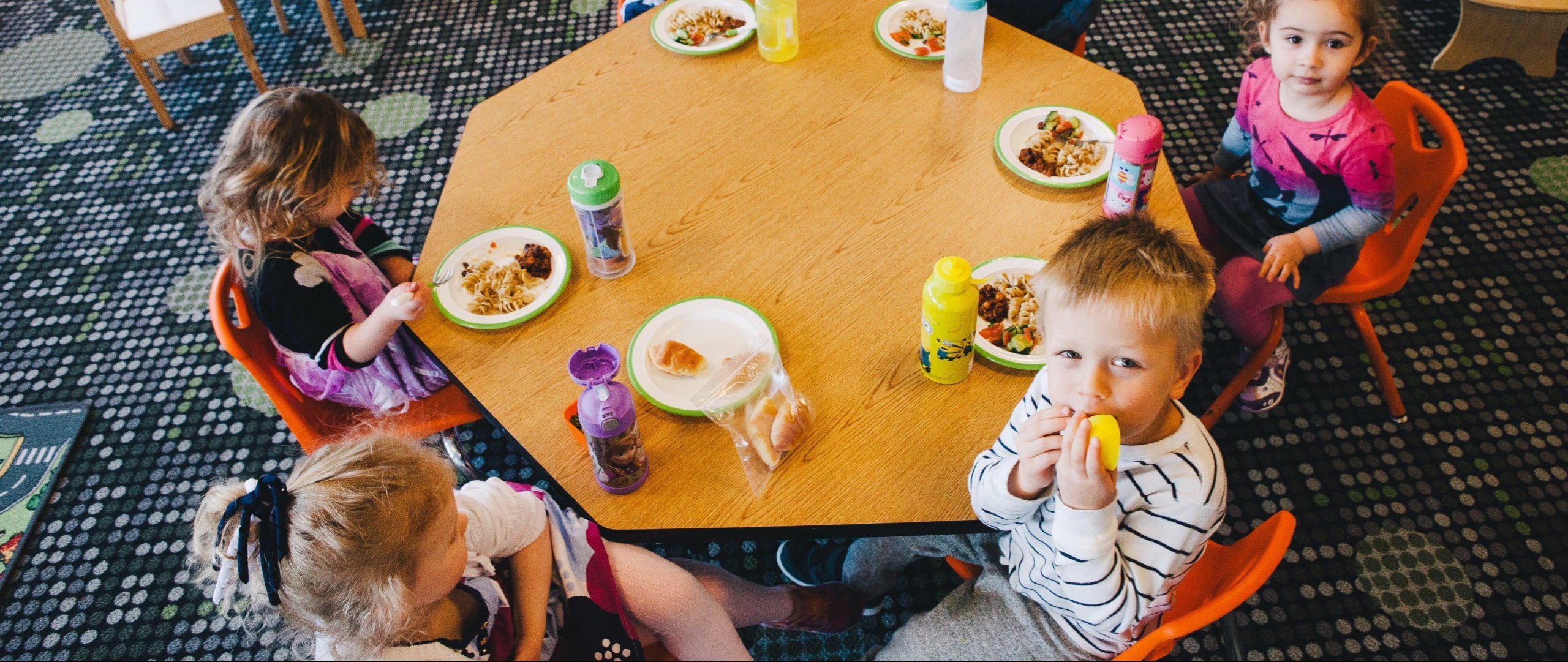 kids in daycare eating at octagonal table