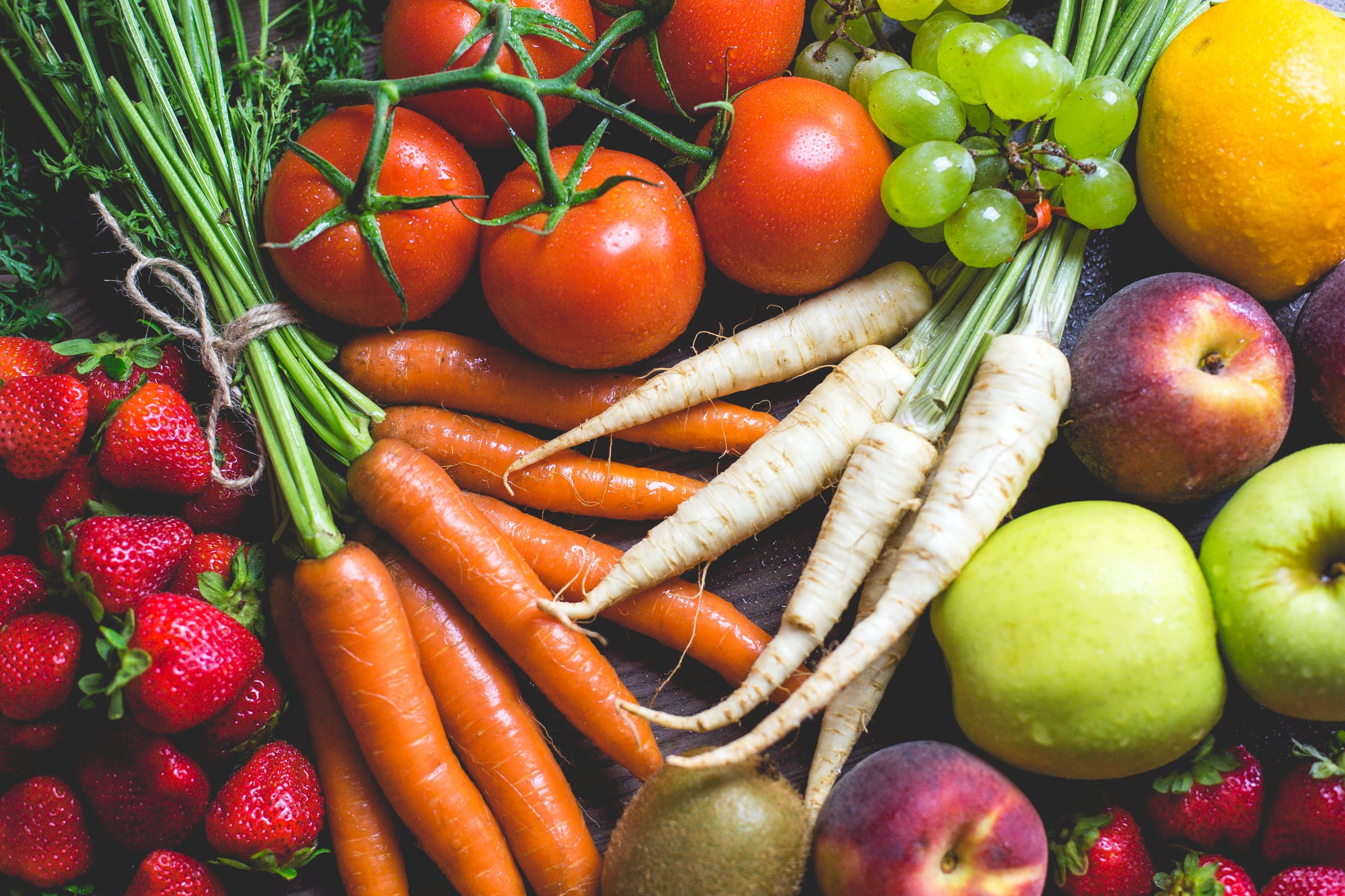assortment of fruits & veggies on dark background, dewy drops