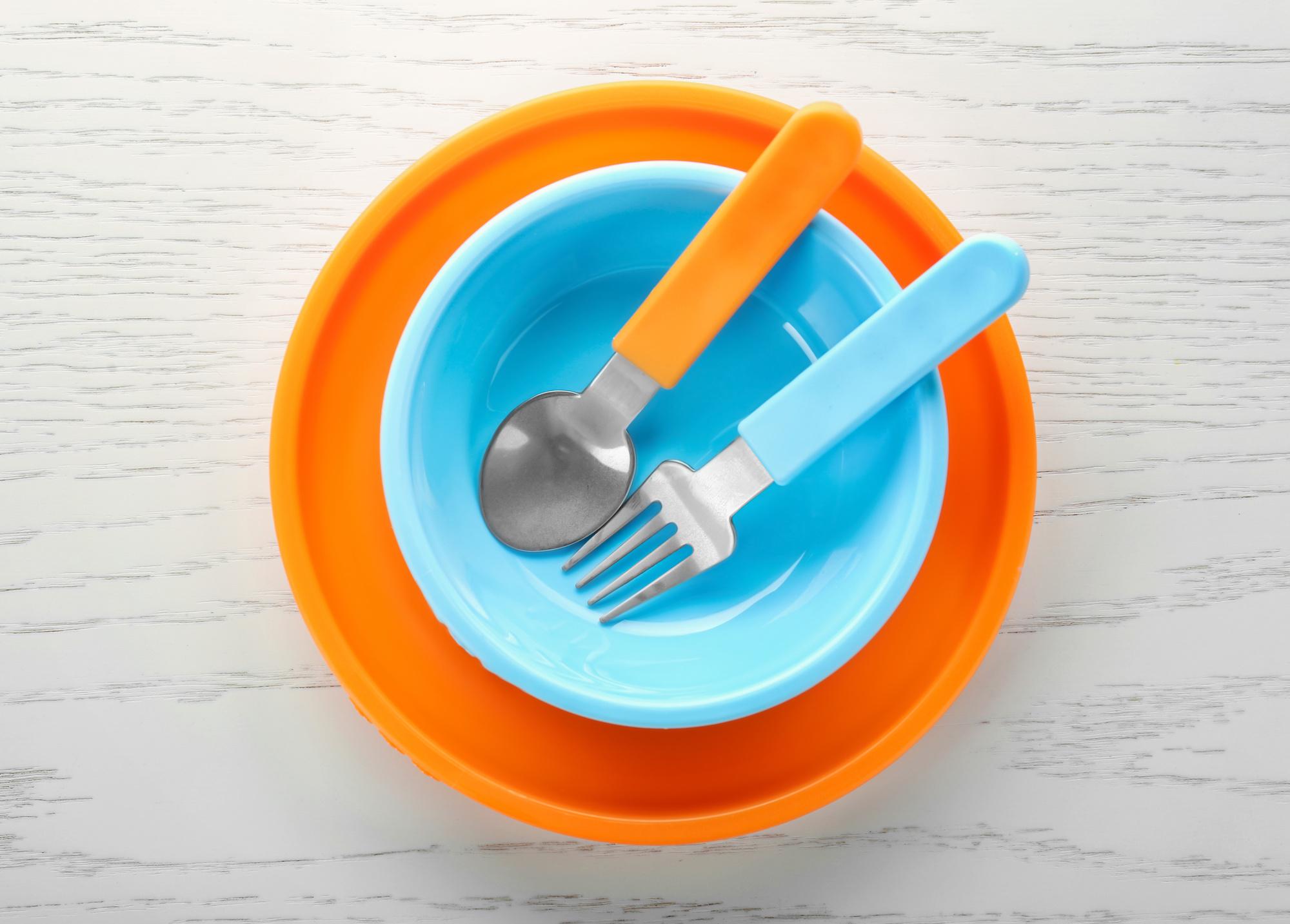 child's blue bow with orange plate and spoon & fork