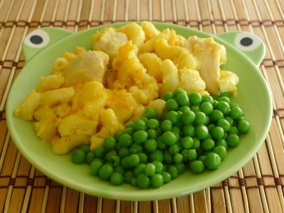 green child's frog plate with macaroni and cheese and green peas