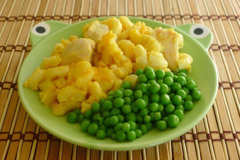 green child's frog plate with macaroni and cheese and green peas