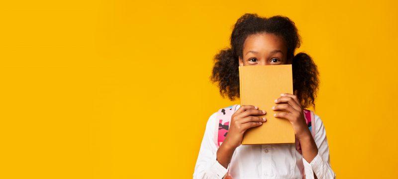 yellow background young girl holding yellow book