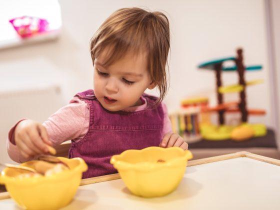 toddler at table with 2 yellow bowls