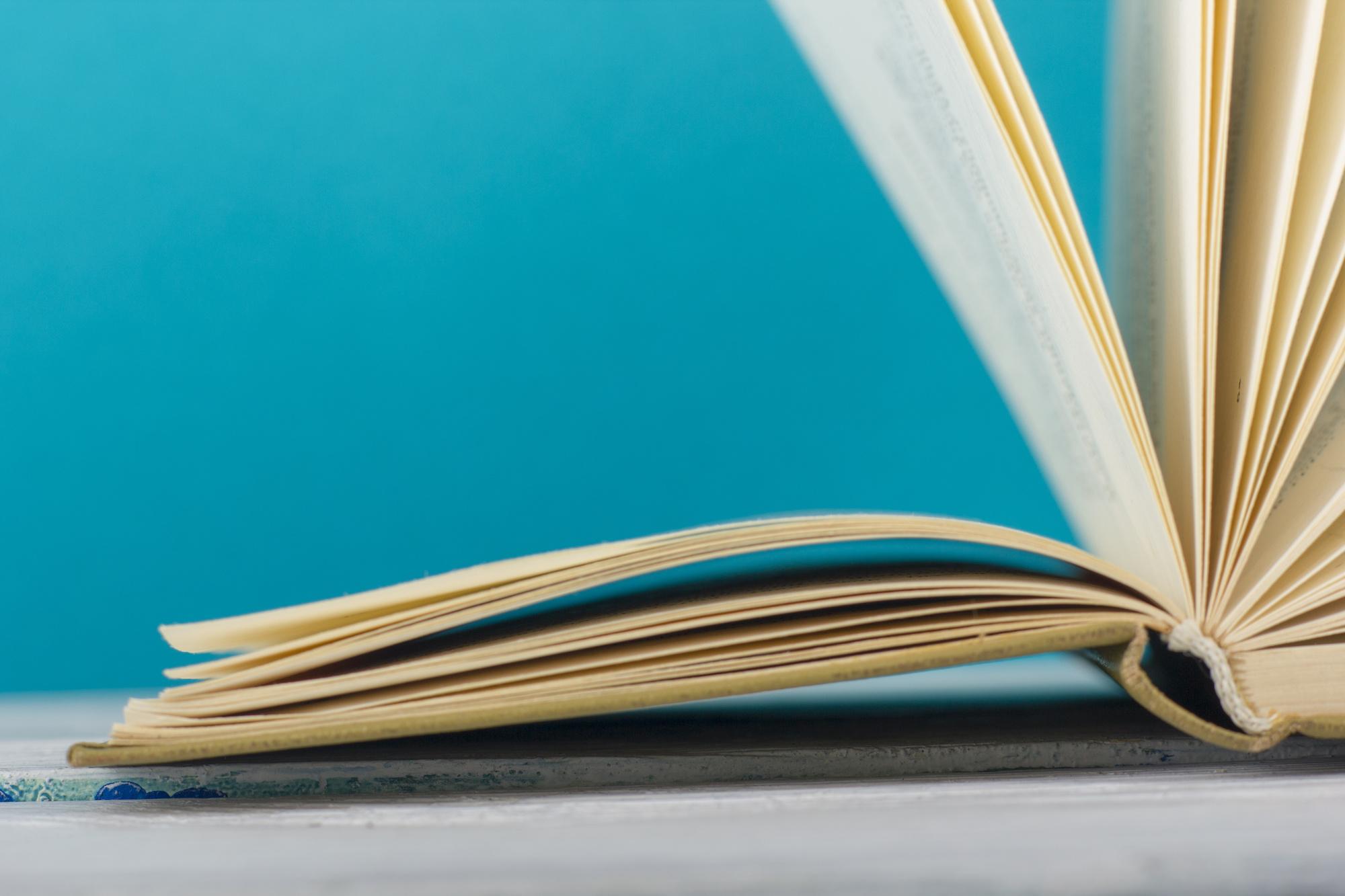 blue background with close up of book pages opening
