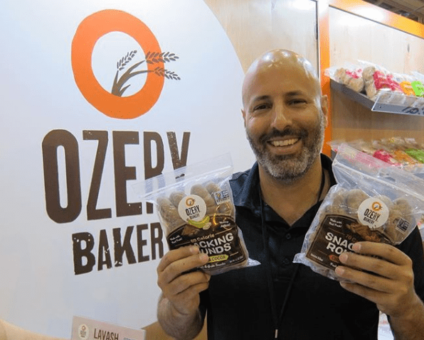 man holding ozery bakery snacking round packages