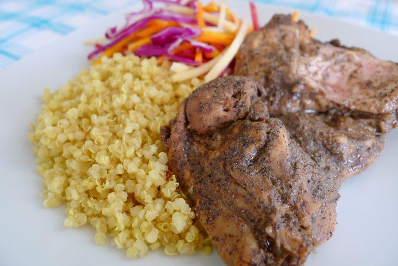 white plate of jerk chicken, quinoa and slaw salad