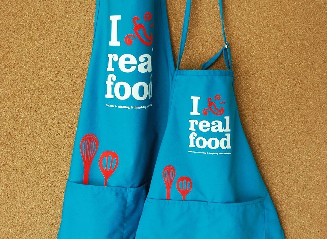 I chili pepper REal Food blue aprons, cork background