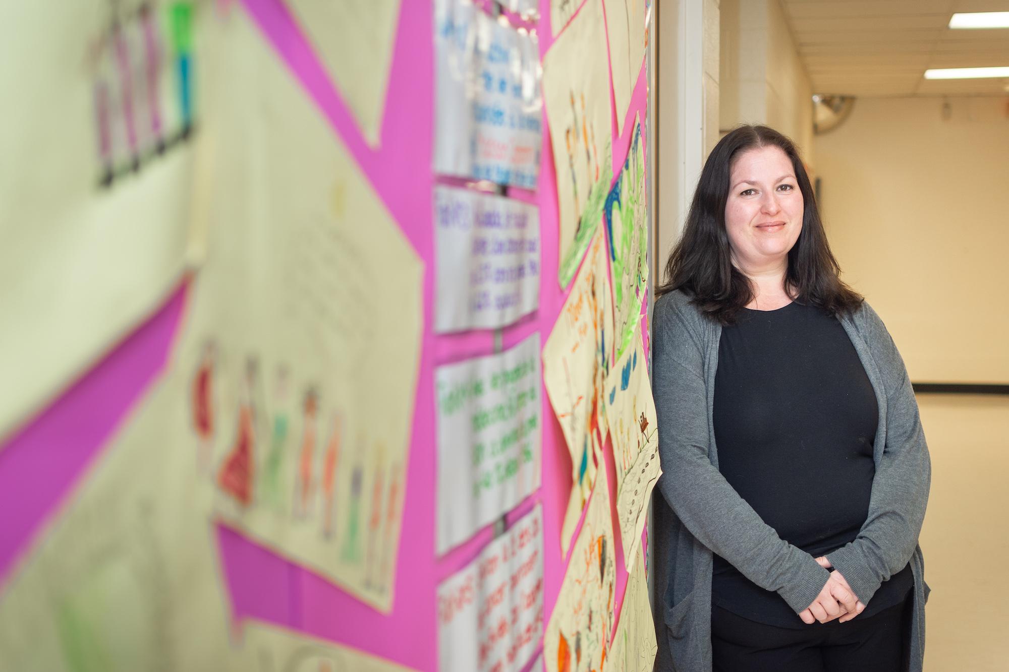 woman against wall of children's artwork
