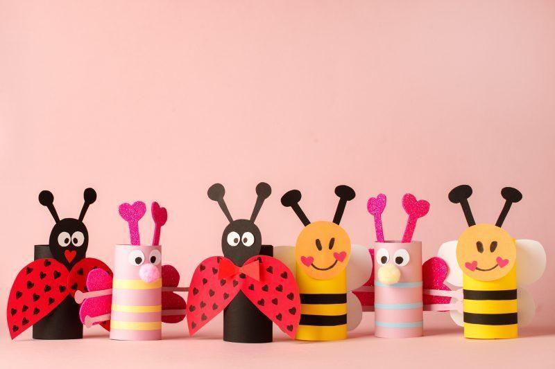 Paper toy insect for valentine romance baby shower, birthday party. Easy crafts for kids on pink background, copy space, die creative idea from toilet tube roll, recycle reuse eco