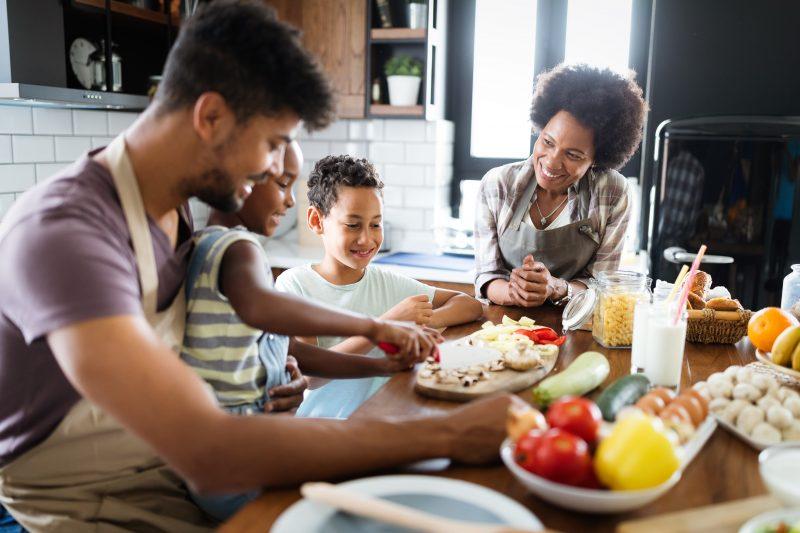 Healthy food at home. Happy black family in the kitchen having fun and cooking together