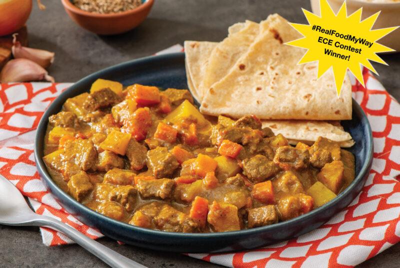 ontario beef with chunks of potato and carrots in trini curry sauce with roti