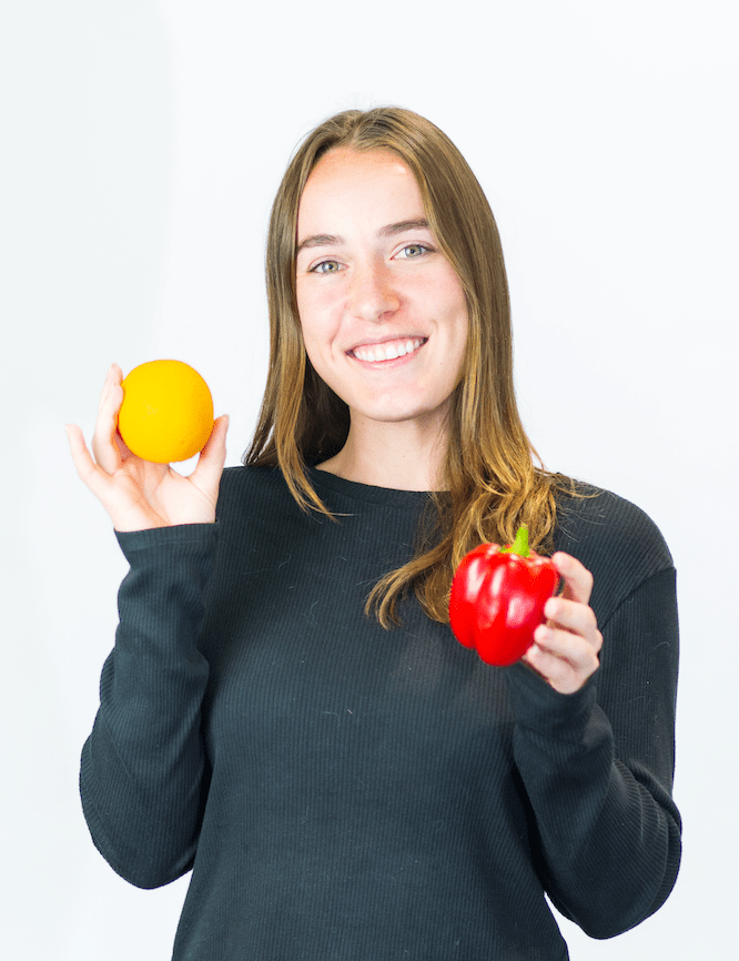 meet jenna, client experience manager holding orange and bell pepper