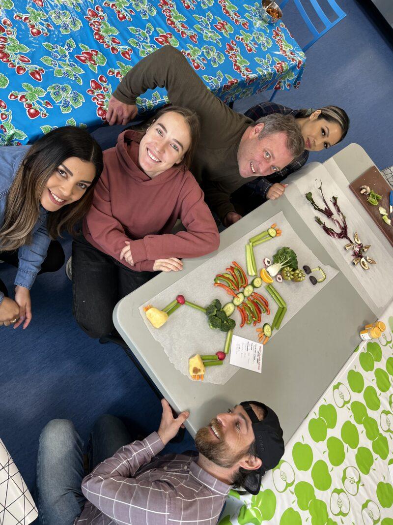 CX team group photo around their veggie artwork