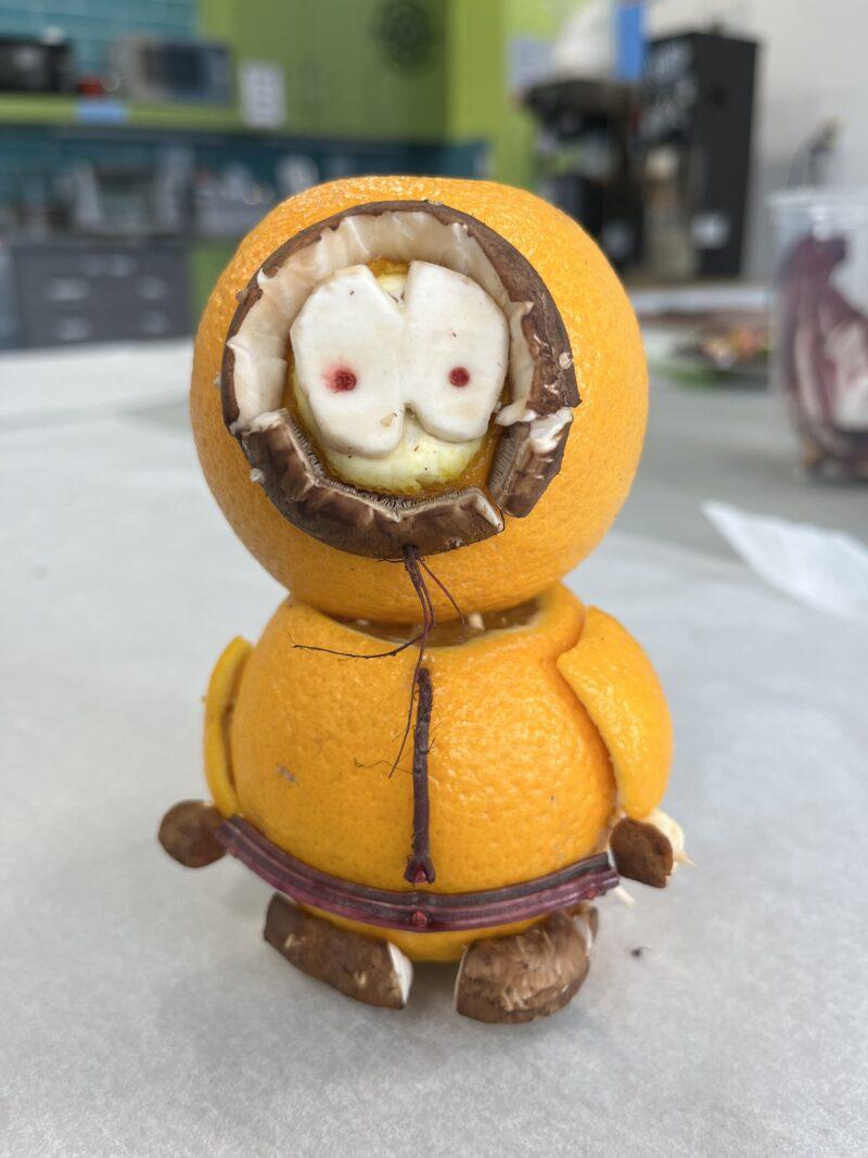 sculpture of kenny from south park made or oranges, mushroom and beet