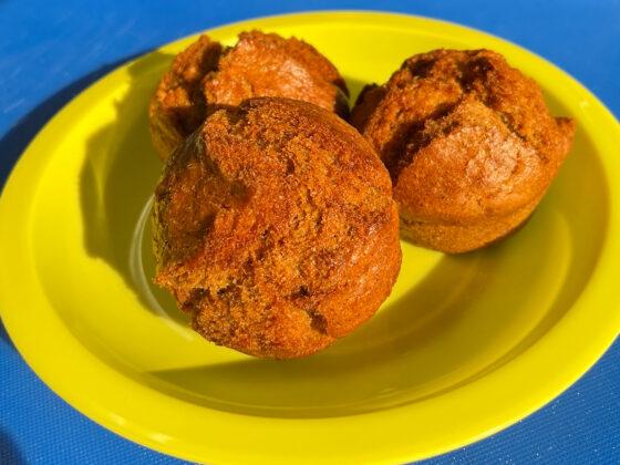 3 banana muffins on yellow plate blue background