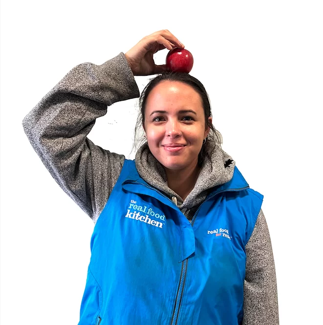 woman posing for meet the team photo holding apple on her head