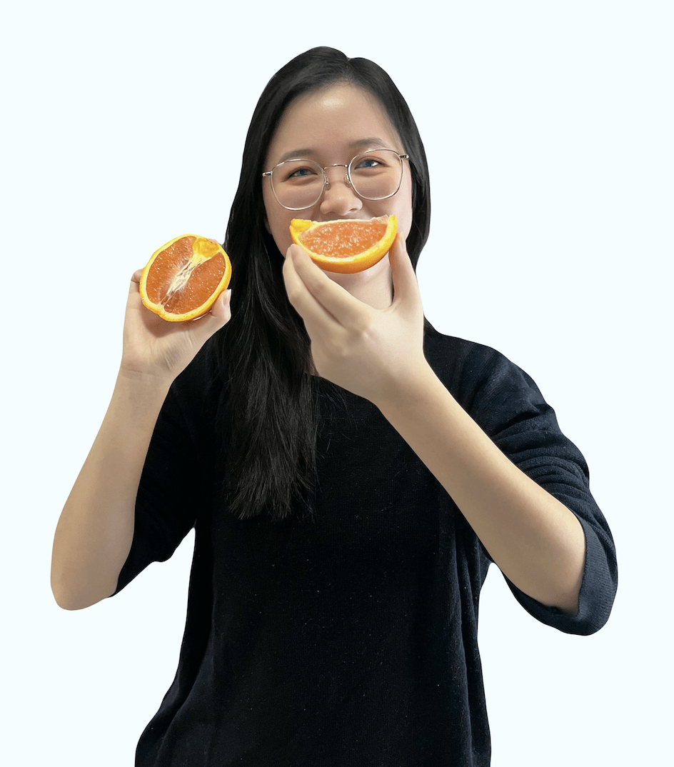 System Administrator, Lily, poses with an orange slice as a smile