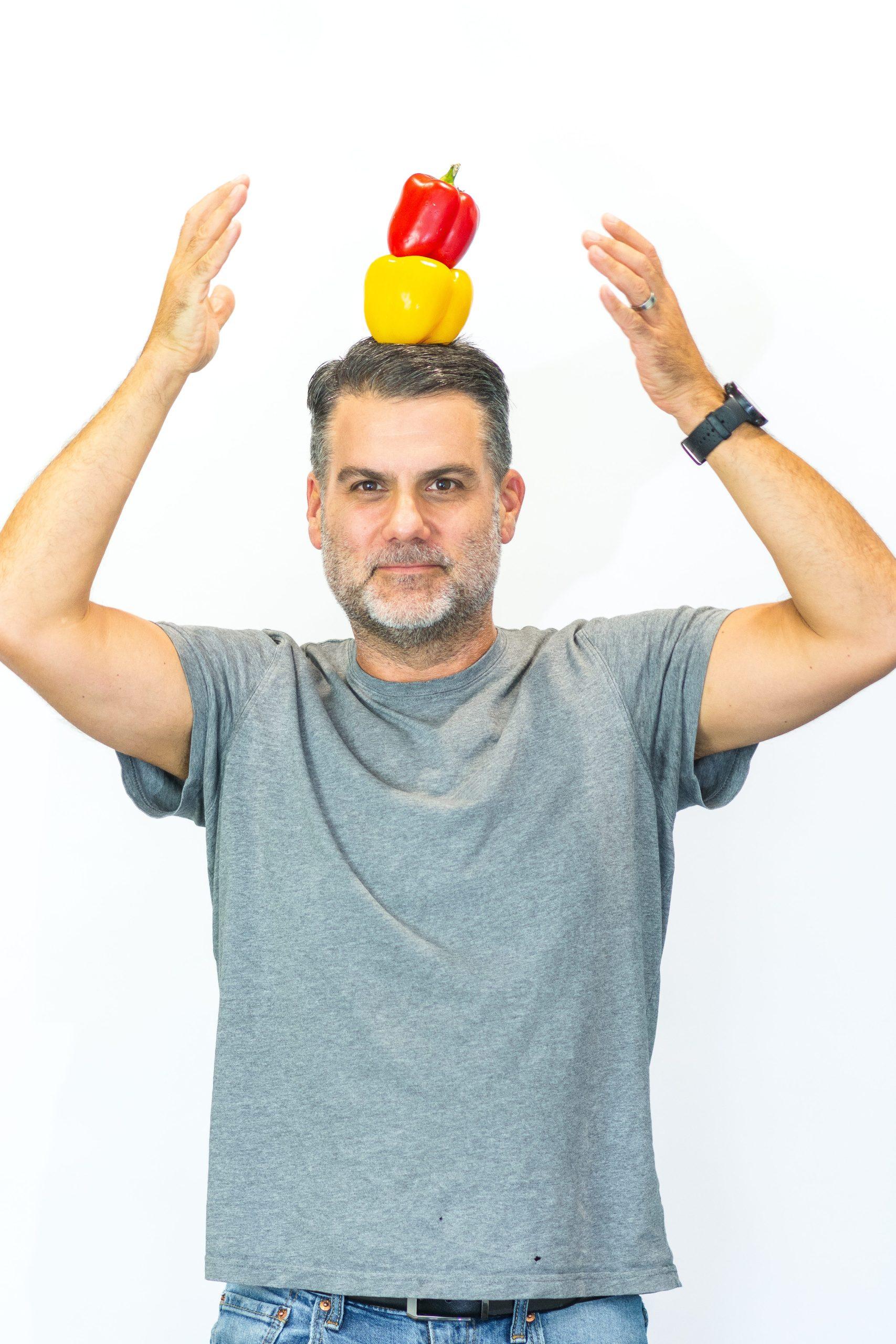 Director of Supply Chain & Logistics, Duncan, poses with two bell peppers balanced on his head