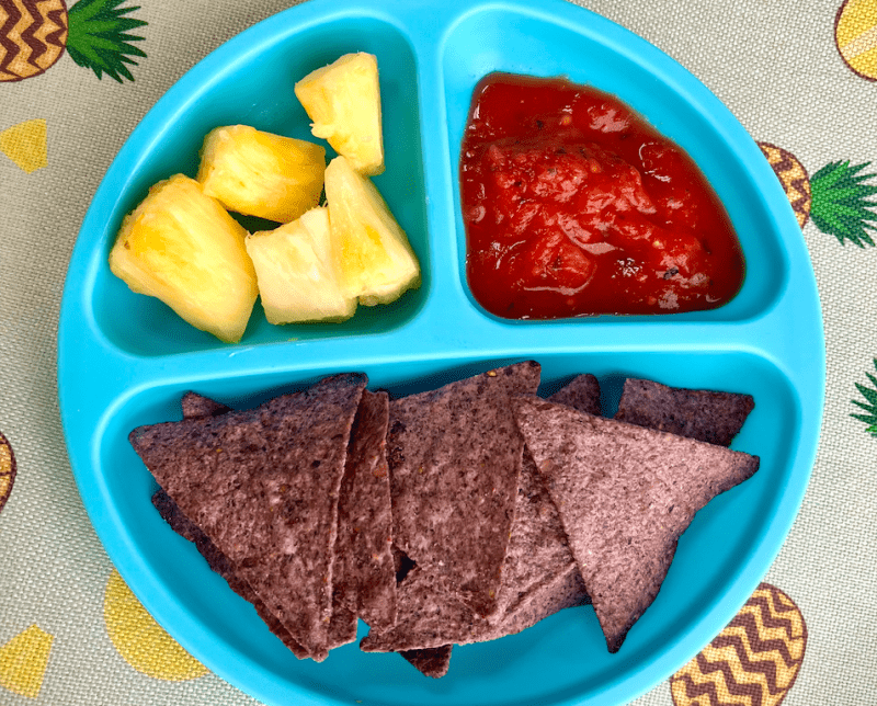 RFRK tomato salsa with blue corn tortilla chips and pineapple chunks in a blue divided child's plate