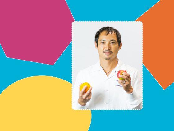 a background of various colourful shapes with a frame featuring a man in a white production shirt posing with an apple and orange in his hands