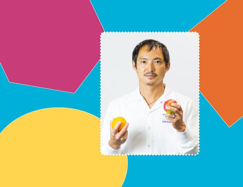 a background of various colourful shapes with a frame featuring a man in a white production shirt posing with an apple and orange in his hands