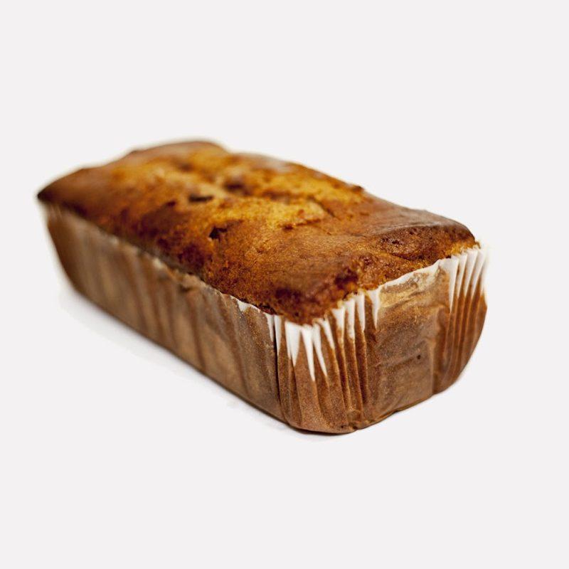 apple cinnamon loaf in a paper liner on a white background