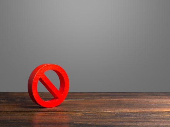 Red prohibited symbol on a wooden table