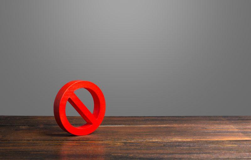 Red prohibited symbol on a wooden table