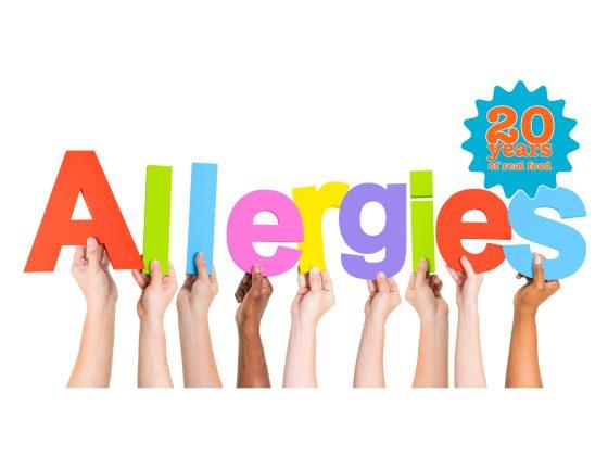 several arms in various skin tones hold up colourful letters to spell out allergies