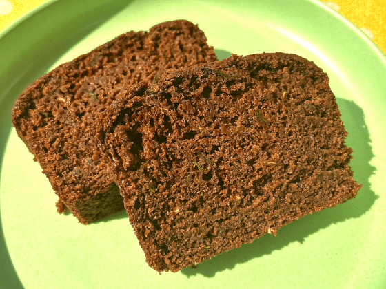 two slices of RFRK cocoa zucchini loaf on a bright green plate