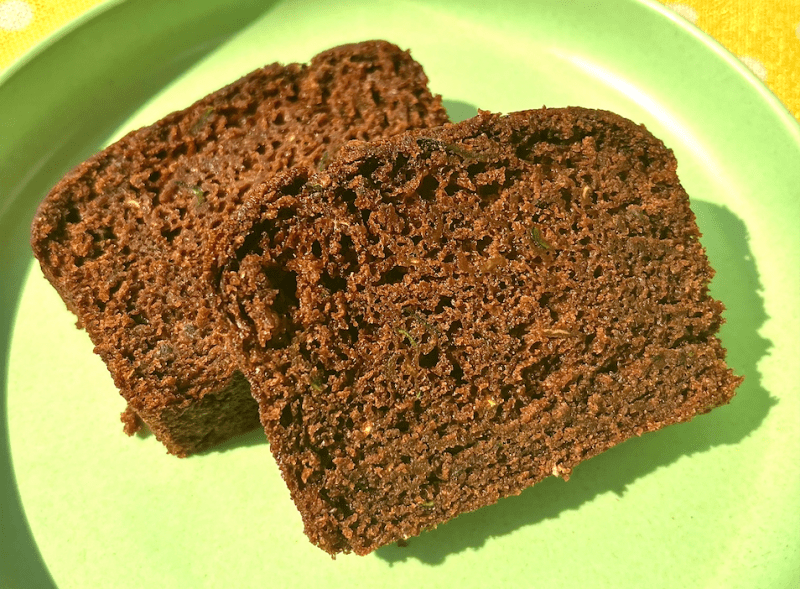 two slices of RFRK cocoa zucchini loaf on a bright green plate