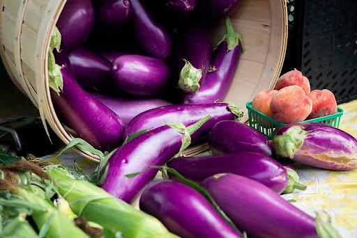 display of medium size purple eggplant cascading from a basket