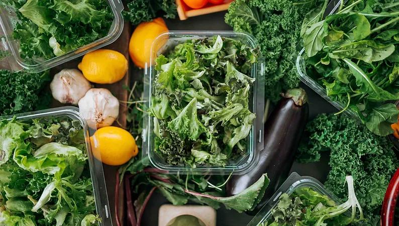 open package of fresh vision greens surrounded by other produce