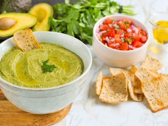 Avocado Bean Guacamole in a bowl with multigrain and chia crisps
