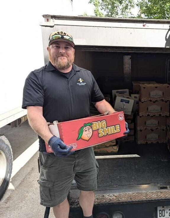 man holding boxes of surplus food ready to be donated