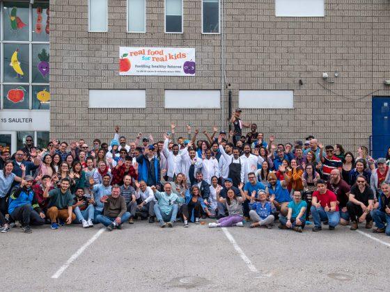 large group shot of RFRK staff in front of facility posing for happy 20th birthday photo