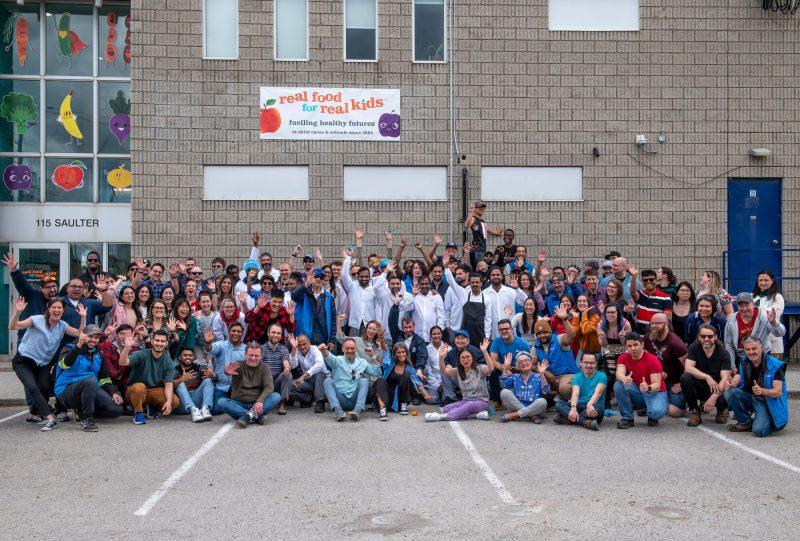 large group shot of RFRK staff in front of facility posing for happy 20th birthday photo