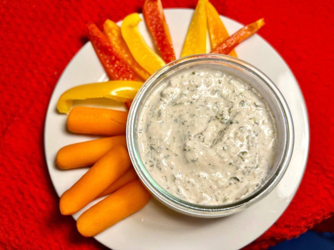 new: saucy dipz! 1 dill saucy dipz on white plate with red and yellow pepper slices and carrots