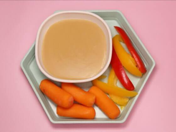 real food for real kids new golden miso dip alongside carrots, peppers for dipping and pink background