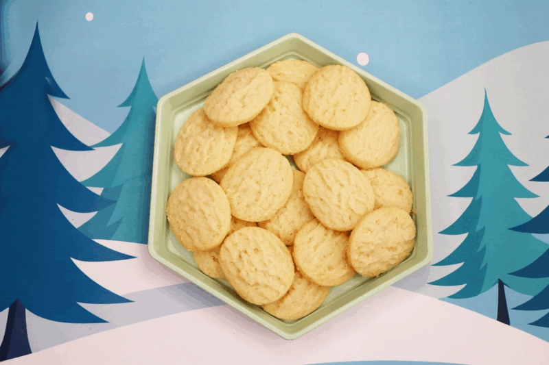 rfrk mini shortbread cookies on hexagonal mint green plate in front of winter scene background