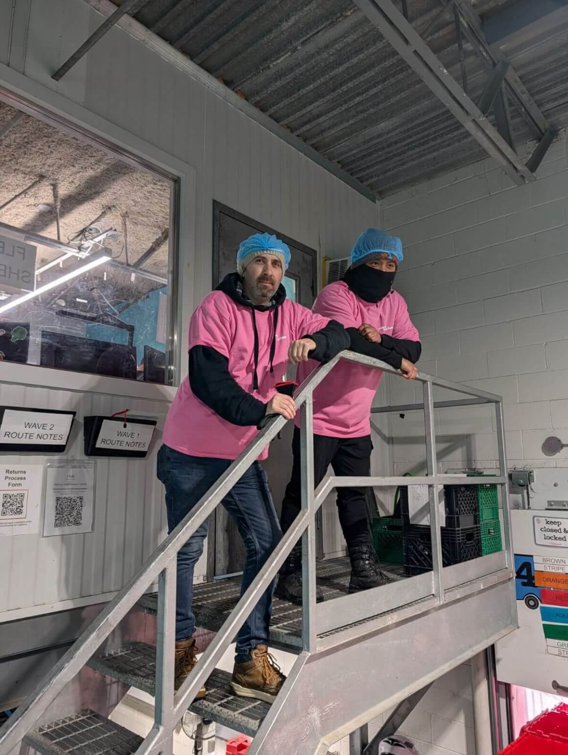 rfrk staff wearing pink shirts for pink shirt day posing for photo leaning over railing
