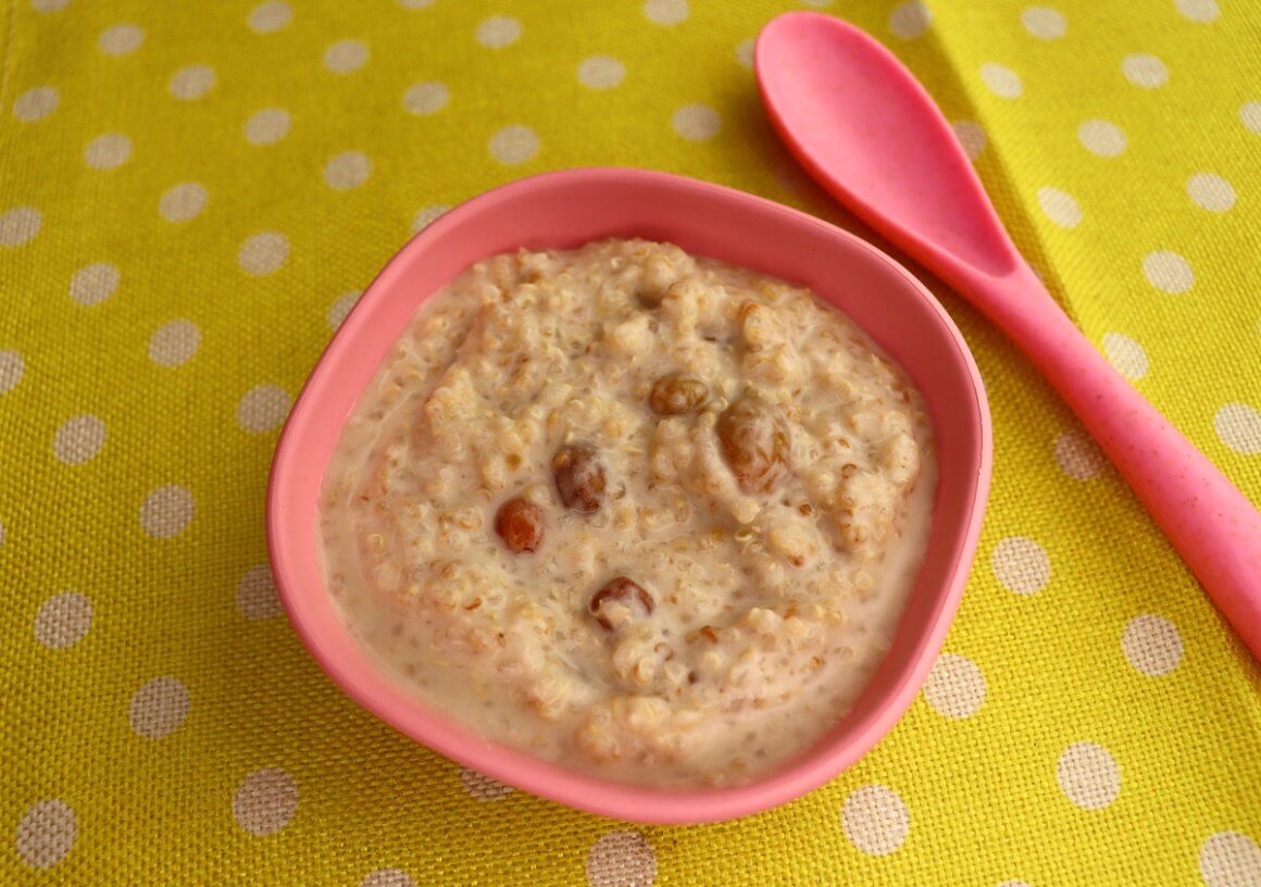 rfrk's coconut quinoa pudding in pink bowl, next to pink spoon on top of yellow placemat with white polka dots served to kids who can't have dairy as a yogurt substitute