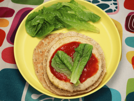 chicken burger on plate with homemade Real Food Ketchup, romaine lettuce pieces and multigrain pita bun