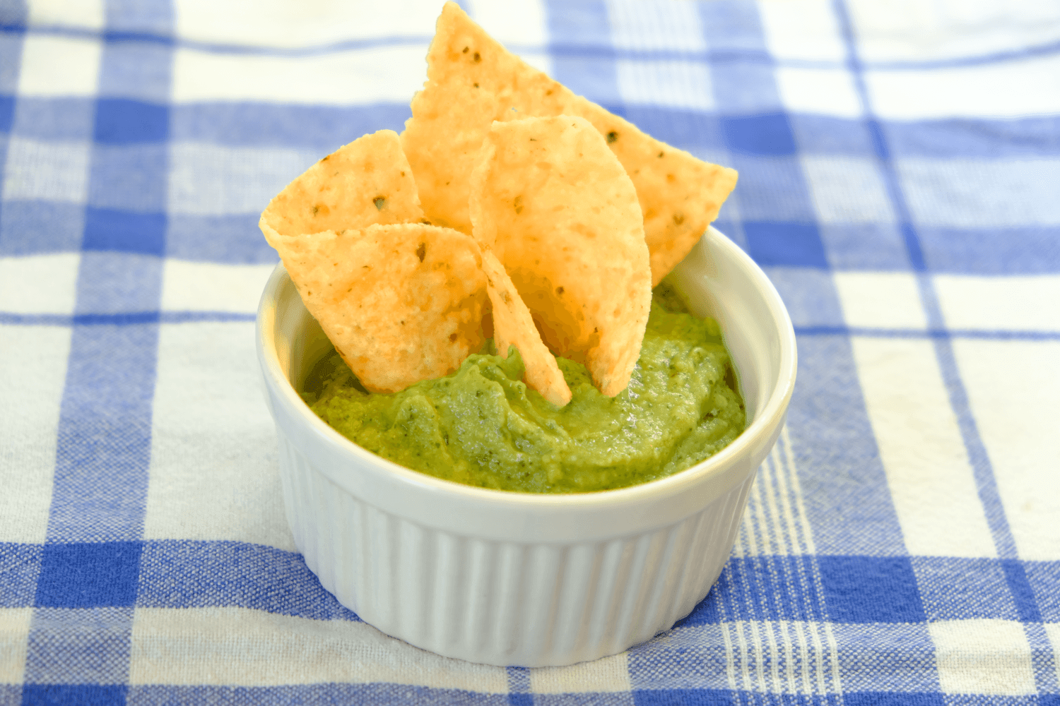 recipe release: avocado bean guacamole! 1 rfrk avocado bean guacamole served in tiny ramekin on top of blue and white checked tablecloth