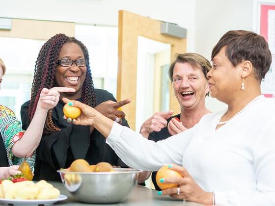 a group of ECE women gathered around a table smiling and bonding